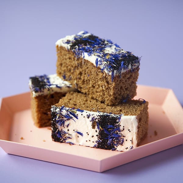Chai & Vanilla Traycake pieces on a pink tray with chai spice frosting.